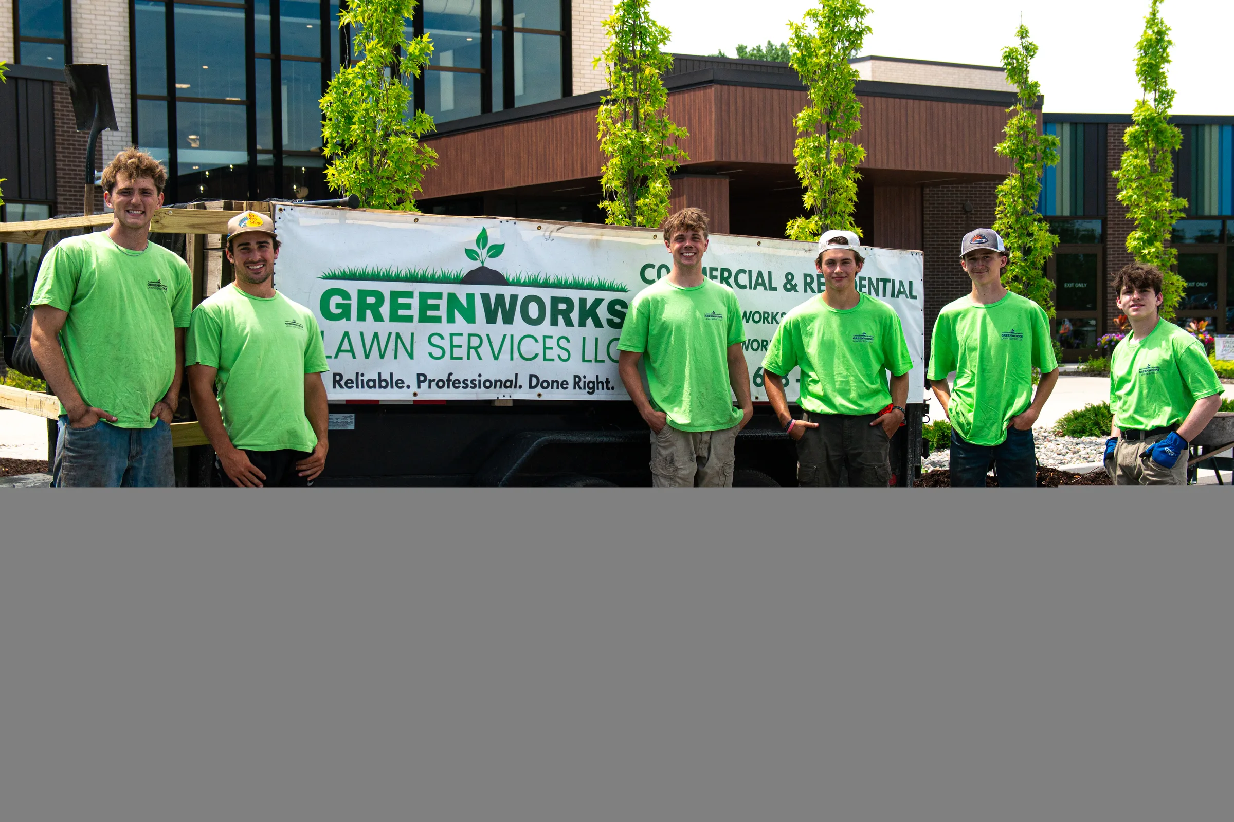 Six members of the Greenworks crew standing in front of the branded Greenworks trailer at the Midland Community Center