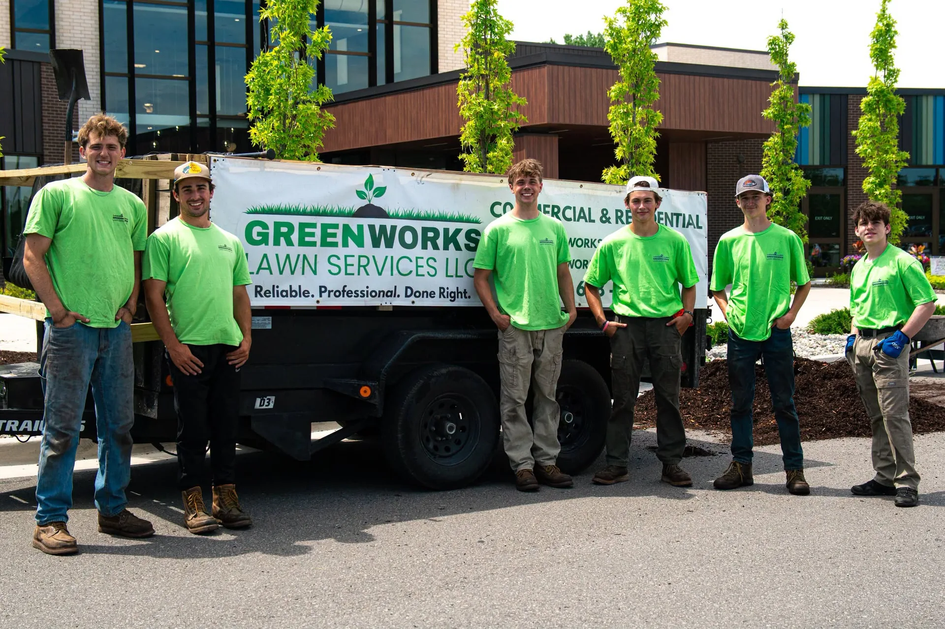Greenworks crew standing together beside the company trailer