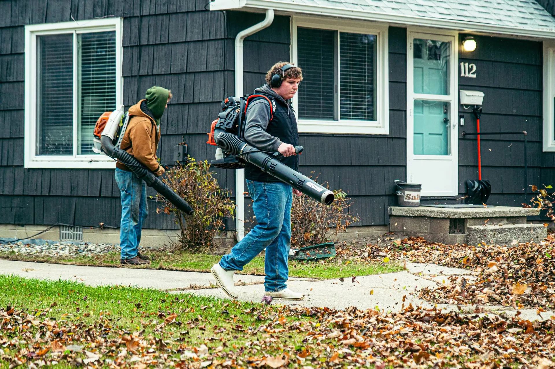 Greenworks crew clearing a residential lawn with backpack blowers