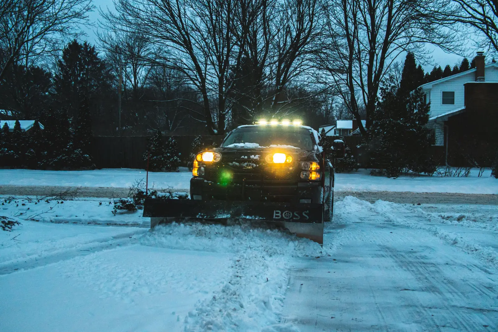 Greenworks plow truck clearing a snowy residential driveway