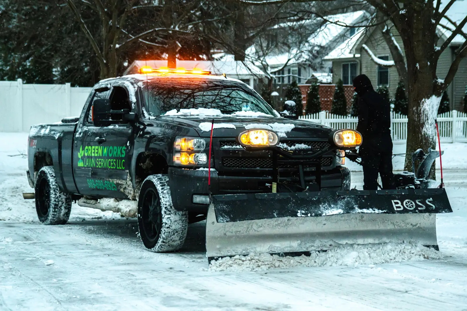 Greenworks plow truck clearing a snow-covered drive