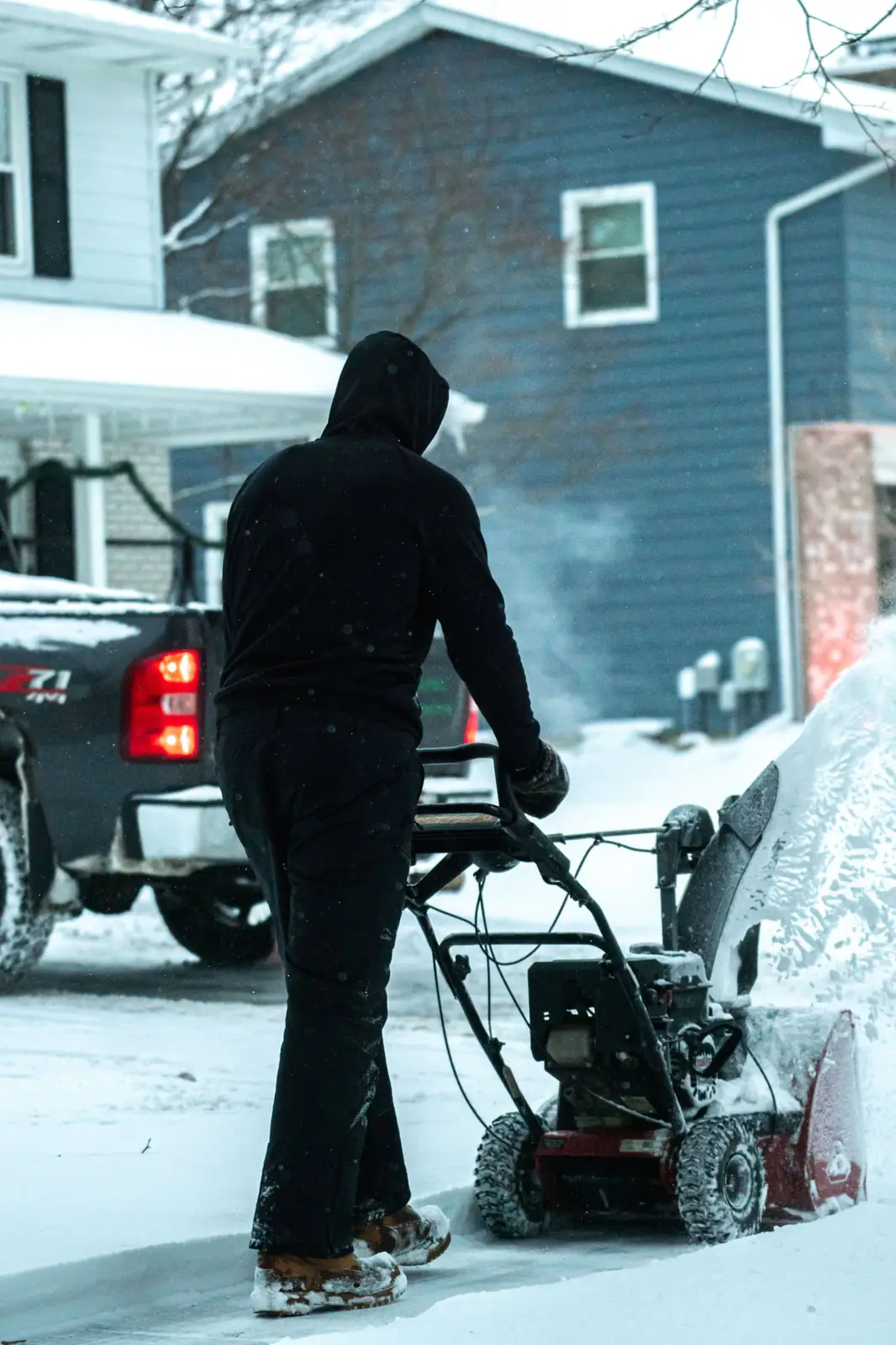 Greenworks plow truck clearing snow near a home